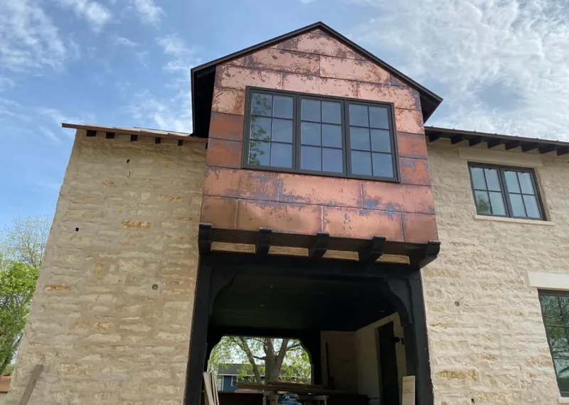 Copper metal panel facade on a stone building for Skylight Installation in Cherokee