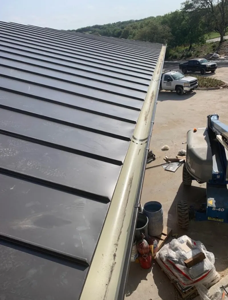 Standing seam panel and gutter detail on a metal roofing jobsite in Cherokee